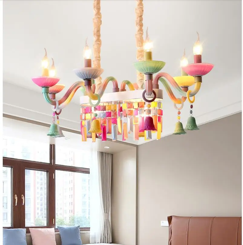 Imagem mostrando um lustre colorido com design em arco-íris instalado em um quarto infantil. O modelo do lustre é de 2024/2025, destacando-se pelas suas cores vibrantes e formas encantadoras que adicionam um toque de magia ao ambiente. No fundo, é possível ver uma decoração de quarto com móveis adequados para crianças, criando um espaço alegre e acolhedor.